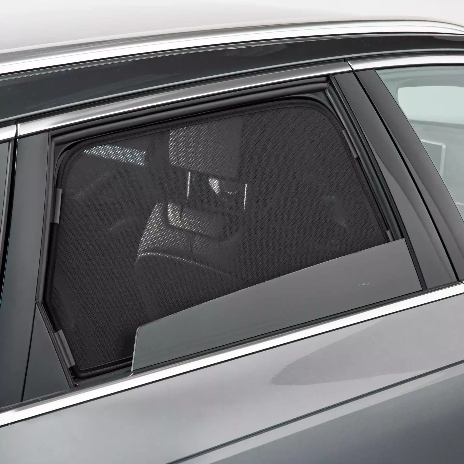 ein SunClip ist an einer heruntergefahrenen Autoscheibe befestigt