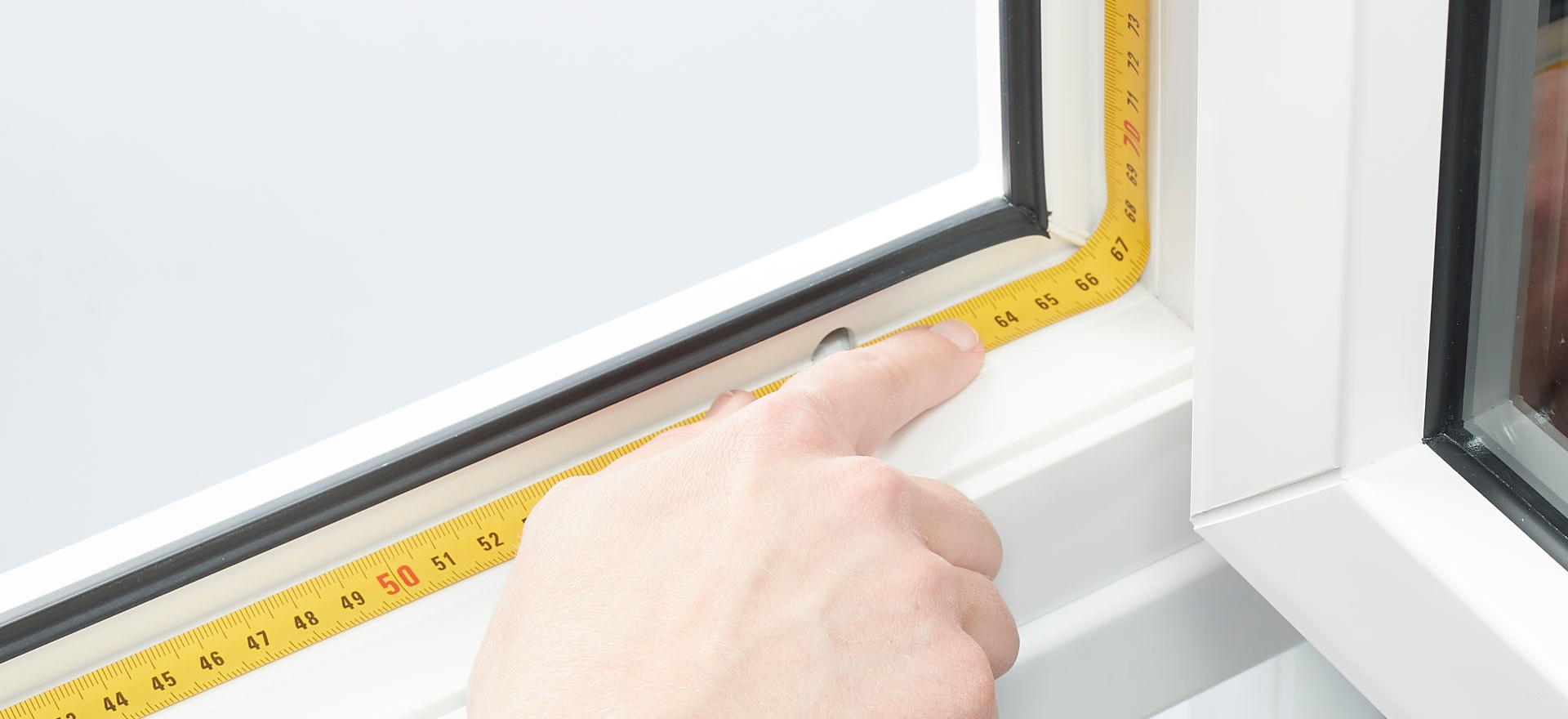 ein Maßband liegt am Fensterrahmen