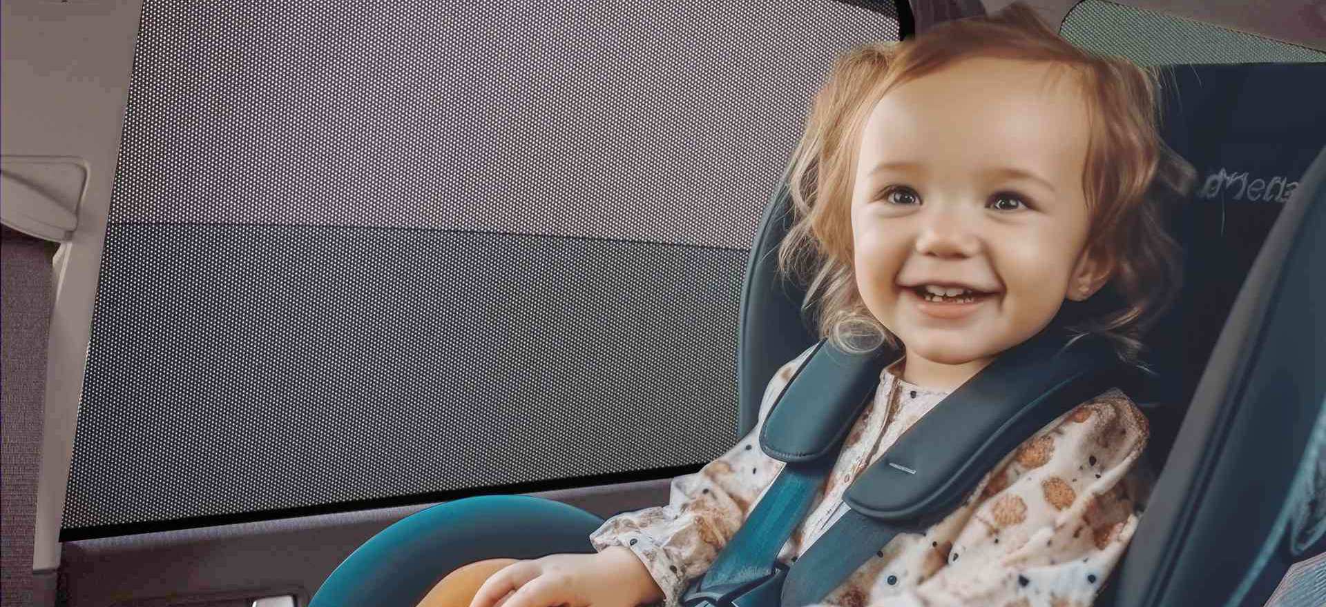 Sun protection in the car for children? Of course! a toddler sits happily in the car with a sunshade on the windscreen